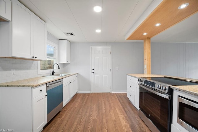 kitchen featuring stainless steel appliances, white cabinets, and a sink