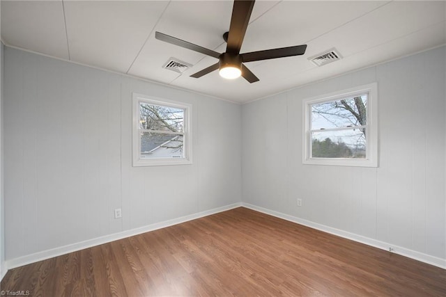 spare room featuring visible vents, a wealth of natural light, and wood finished floors