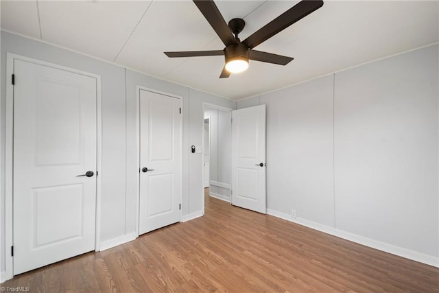 unfurnished bedroom featuring baseboards, ceiling fan, and light wood finished floors