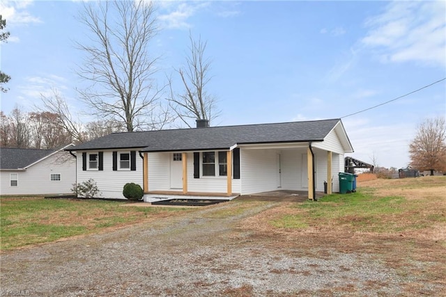 ranch-style home featuring driveway, an attached carport, and a front yard