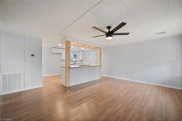 unfurnished living room featuring ceiling fan, wood finished floors, and visible vents