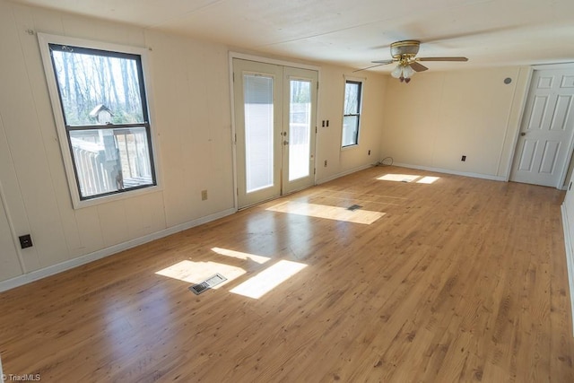 interior space featuring visible vents, a wealth of natural light, light wood-style flooring, french doors, and a ceiling fan