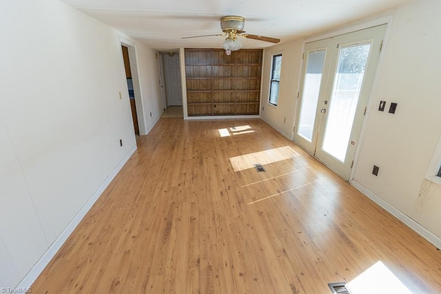 interior space with light wood finished floors, french doors, baseboards, and ceiling fan