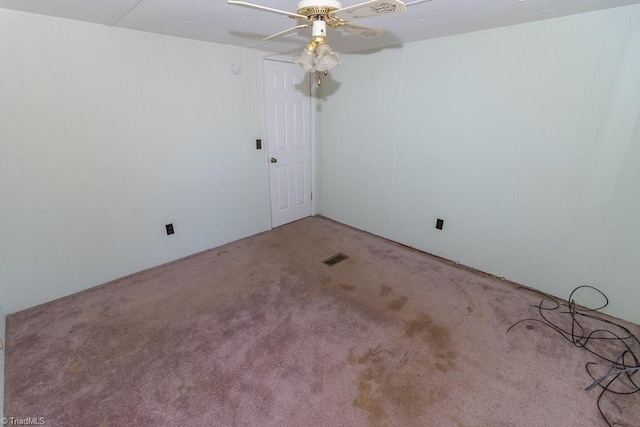 carpeted spare room with a ceiling fan