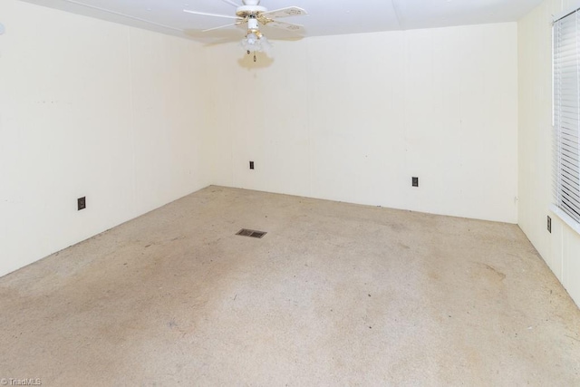 carpeted spare room featuring visible vents and ceiling fan