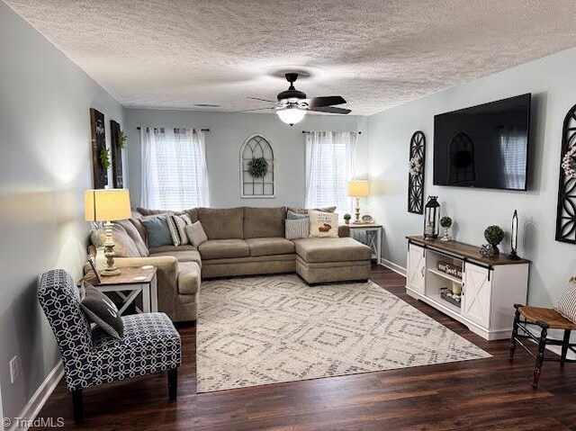 525 Bennett St, Mount Airy, NC 27030 - living area with a textured ceiling, ceiling fan, dark wood-style floors, and baseboards