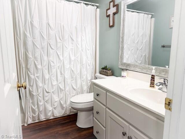 525 Bennett St, Mount Airy, NC 27030 - full bath with wood finished floors, vanity, toilet, and curtained shower