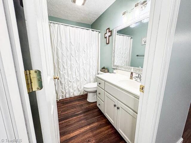 525 Bennett St, Mount Airy, NC 27030 - bathroom featuring vanity, toilet, a textured ceiling, wood finished floors, and a shower with shower curtain