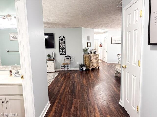 525 Bennett St, Mount Airy, NC 27030 - hall featuring a sink, dark wood-style flooring, a textured ceiling, and baseboards