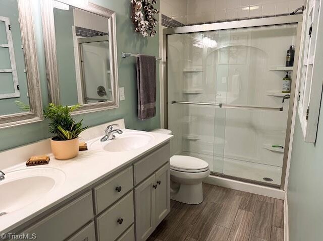 525 Bennett St, Mount Airy, NC 27030 - bathroom featuring toilet, a shower stall, double vanity, and wood finished floors