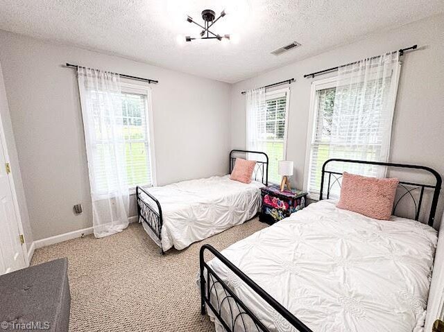 525 Bennett St, Mount Airy, NC 27030 - bedroom featuring a textured ceiling, carpet, baseboards, and a chandelier
