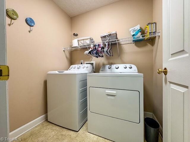 525 Bennett St, Mount Airy, NC 27030 - laundry room with washing machine and dryer, baseboards, light tile patterned floors, and a textured ceiling