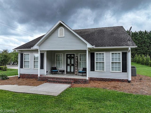 525 Bennett St, Mount Airy, NC 27030 - view of front of property featuring covered porch, a front yard, central AC unit, and a shingled roof
