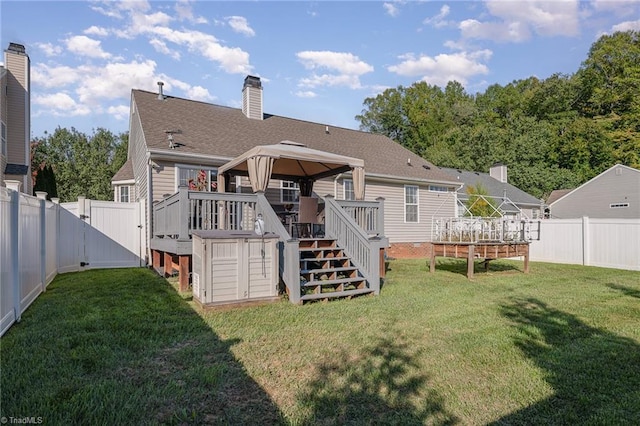 back of house featuring a gazebo, a deck, and a yard