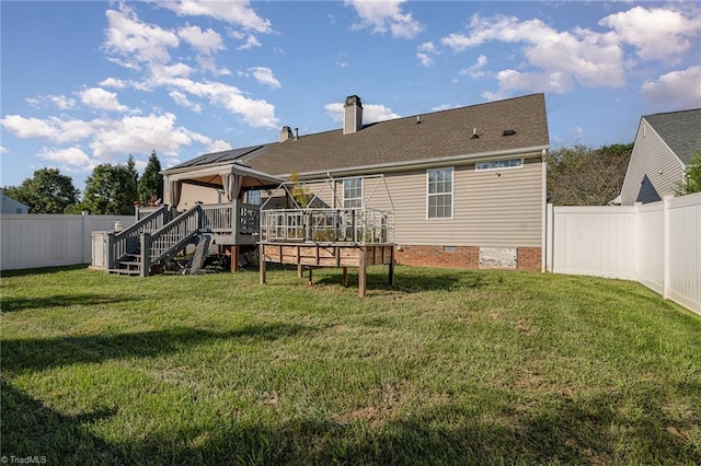 rear view of property with a yard and a wooden deck