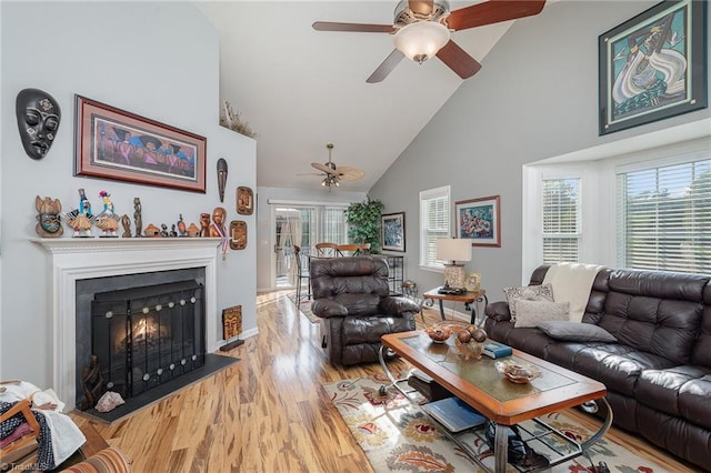 living room featuring light wood-type flooring, high vaulted ceiling, and ceiling fan