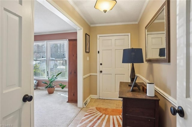 entrance foyer featuring ornamental molding and light colored carpet