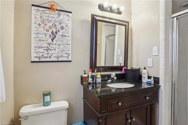 bathroom with vanity, a shower with shower door, and toilet