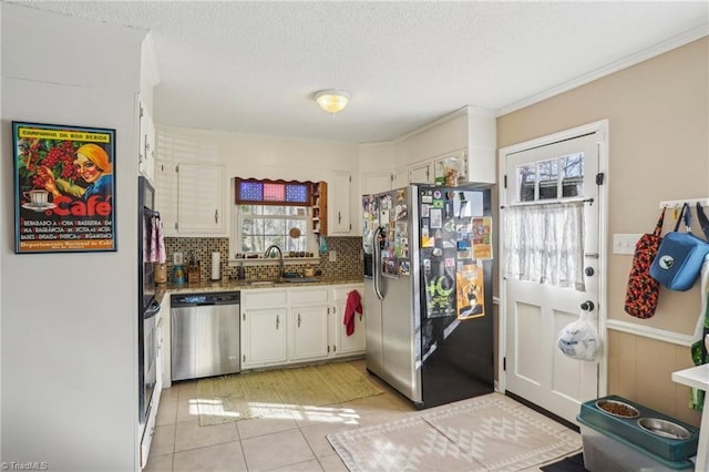 kitchen featuring stainless steel appliances, white cabinetry, sink, and decorative backsplash