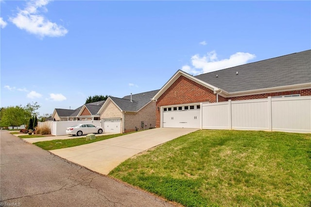 1442 Crestlawn Trl, Pfafftown, NC 27040 - view of front of home featuring a garage, fence, concrete driveway, brick siding, and a front lawn