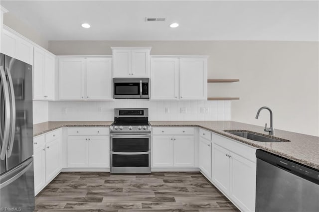 1442 Crestlawn Trl, Pfafftown, NC 27040 - kitchen featuring open shelves, white cabinets, visible vents, stainless steel appliances, and a sink