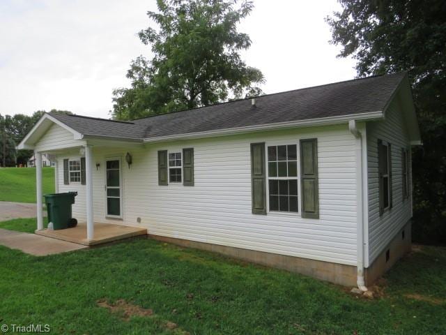 back of property featuring a patio area and a lawn