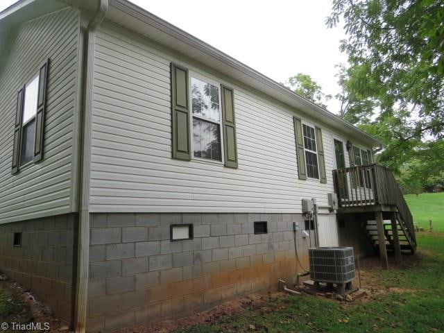 view of side of home with central AC