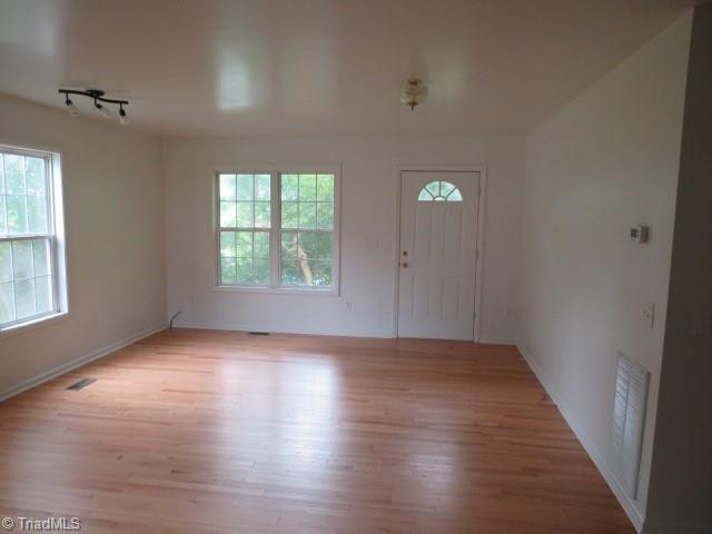 foyer entrance with track lighting and light hardwood / wood-style floors