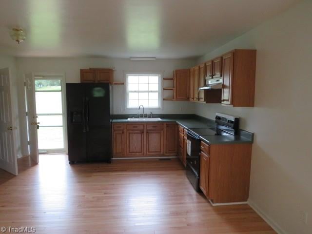 kitchen with sink, black appliances, and light wood-type flooring