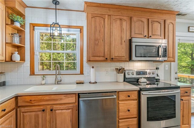 kitchen featuring crown molding, a wealth of natural light, visible vents, appliances with stainless steel finishes, and a sink
