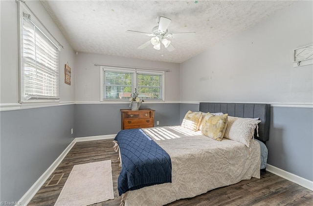 bedroom with baseboards, wood finished floors, and a textured ceiling