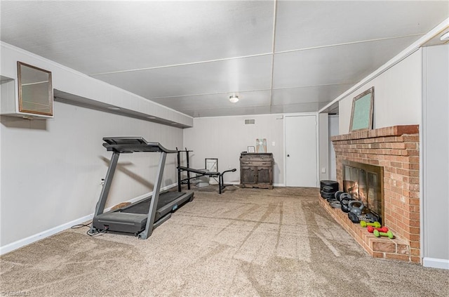 exercise room with visible vents, carpet floors, baseboards, and a brick fireplace
