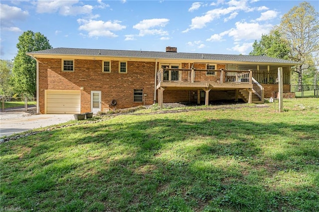 rear view of house featuring a yard, brick siding, an attached garage, a chimney, and concrete driveway