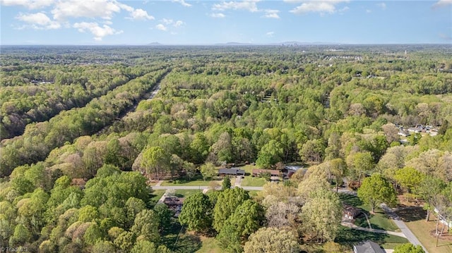 drone / aerial view with a wooded view