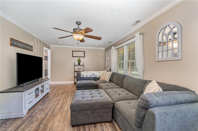 living area featuring visible vents, a ceiling fan, ornamental molding, and wood finished floors