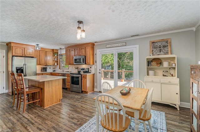 kitchen with a center island, light countertops, dark wood-style floors, crown molding, and stainless steel appliances