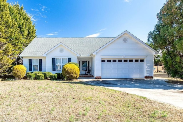 ranch-style house featuring driveway, an attached garage, a front lawn, and a shingled roof