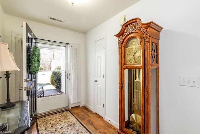 doorway to outside with wood finished floors, visible vents, and baseboards