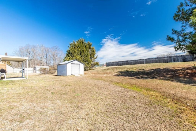 view of yard with a shed, an outdoor structure, and fence