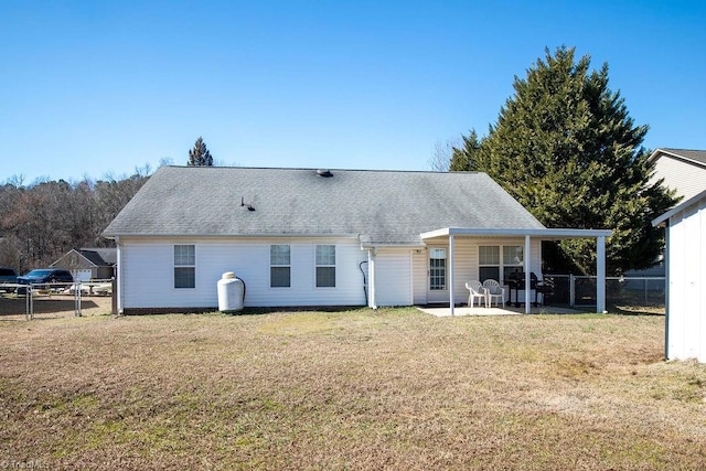 back of house featuring a patio area, roof with shingles, a lawn, and fence