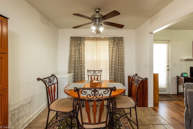 dining room with baseboards, a ceiling fan, and a healthy amount of sunlight