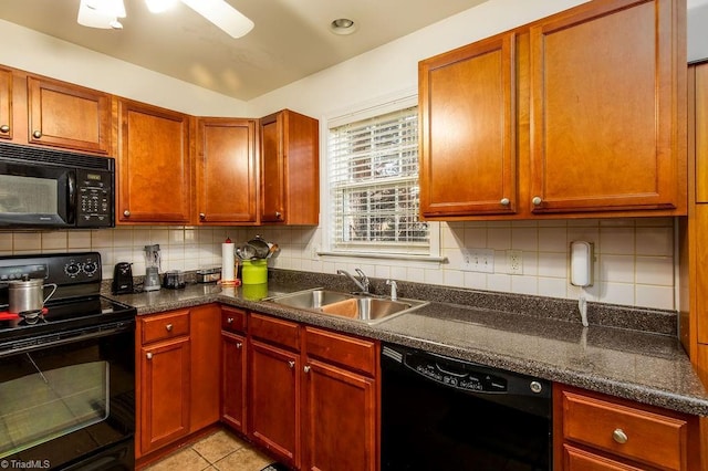 kitchen with light tile patterned floors, dark countertops, a sink, black appliances, and backsplash