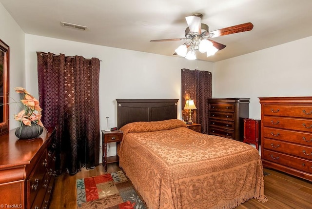 bedroom with dark wood finished floors, visible vents, and a ceiling fan