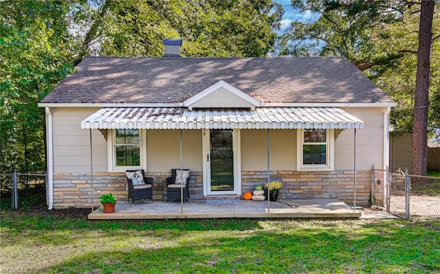 back of property with a lawn and a patio