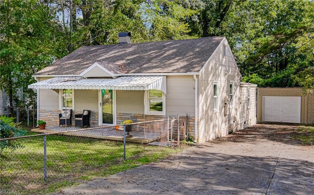 view of front facade featuring an outbuilding, a garage, and a front yard