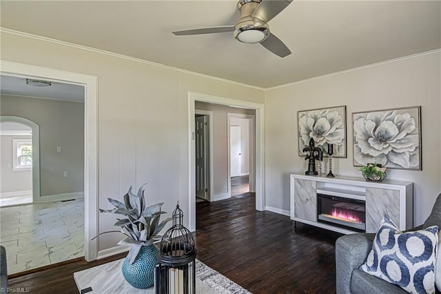 living room featuring a premium fireplace, dark wood-type flooring, and crown molding