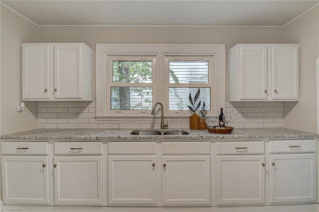 kitchen featuring white cabinetry, tasteful backsplash, and sink