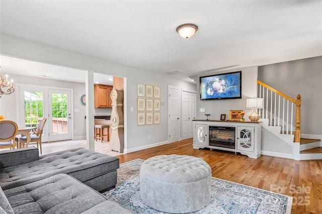 845 Montgomery Ct, Walnut Cove, NC 27052 - living room featuring light wood-type flooring, stairs, a chandelier, and baseboards