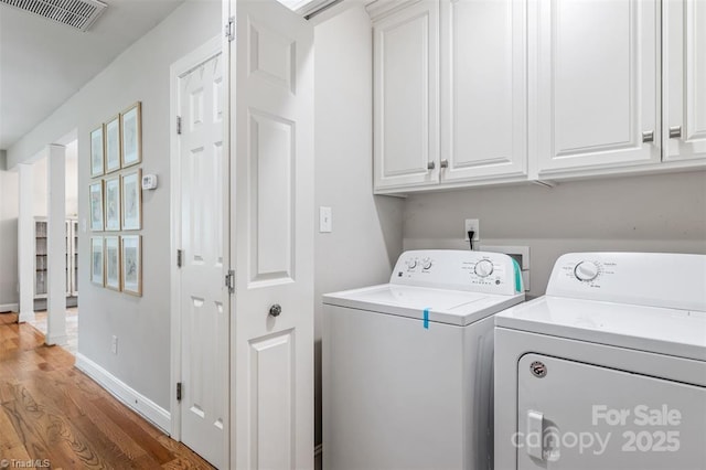 845 Montgomery Ct, Walnut Cove, NC 27052 - laundry area featuring cabinet space, washing machine and dryer, light wood-type flooring, and baseboards