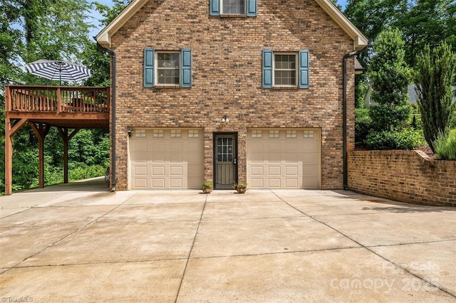 845 Montgomery Ct, Walnut Cove, NC 27052 - view of front of property with a garage, concrete driveway, a wooden deck, and brick siding